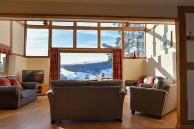 a living room with couches and a large window at The Hayloft in Knighton