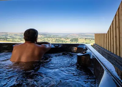 a man sitting in a bath tub in a bath tub at Valley View in Llanfair Caereinion