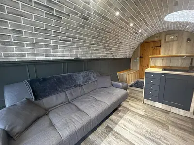 a living room with a couch and a brick wall at Valley View in Llanfair Caereinion