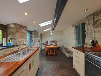 a kitchen with a sink and a table in it at Y Cwtch - Panoramic mountain views within Snowdonia's National Park - 4x4 only in Dolgellau