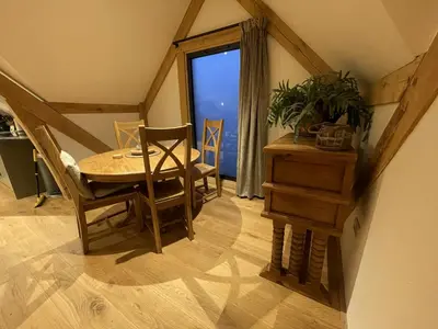 a dining room with a table and chairs and a window at Upper Gelli Luxury Holiday Lodge, Converted Dairy & Cosy Shepherds Huts in Welshpool