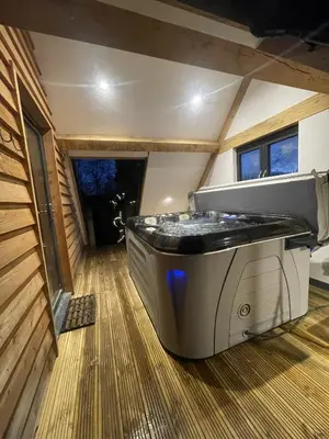 a large tub sitting in the middle of a room at Upper Gelli Luxury Holiday Lodge, Converted Dairy & Cosy Shepherds Huts in Welshpool
