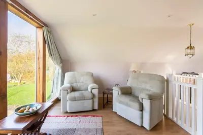 a living room with two chairs and a table at Delightful Country Cottage in a lovely rural area in Ludlow