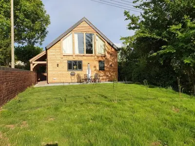 a small wooden house on a grass field at Delightful Country Cottage in a lovely rural area in Ludlow