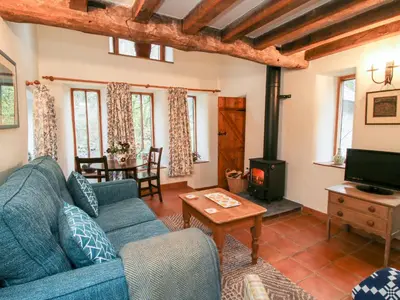 a living room with a blue couch and a wood stove at Walkmill Barn in Bishops Castle