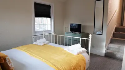 a bedroom with a bed with a yellow blanket at Abbey Foregate in Shrewsbury