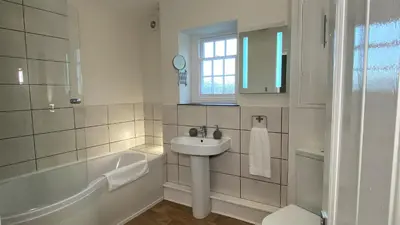a white bathroom with a sink and a bath tub at Abbey Foregate in Shrewsbury