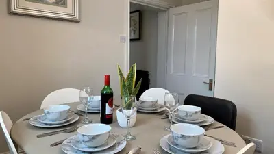 a dining room table with plates and a bottle of wine at Abbey Foregate in Shrewsbury