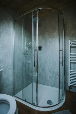 a shower with a glass door in a bathroom at Bluebell in Rhayader