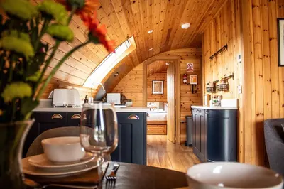 a kitchen with a table with a wine glass at Bluebell in Rhayader