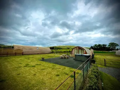 a barn with a fence and a grass field at Buttercup in Rhayader