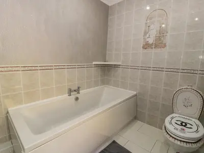 a bathroom with a white tub and a toilet at Bryn Berthen in Penrhyndeudreath