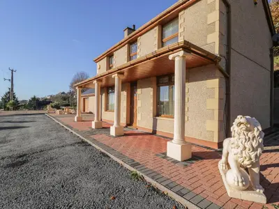 a building with a statue in front of a street at Bryn Berthen in Penrhyndeudreath