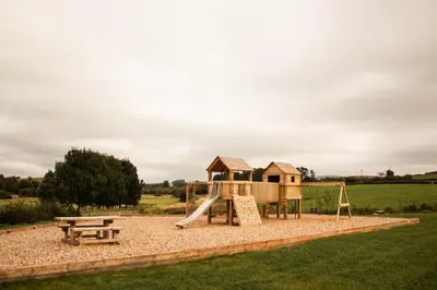 a playground with a slide and a bench at Lily in Rhayader