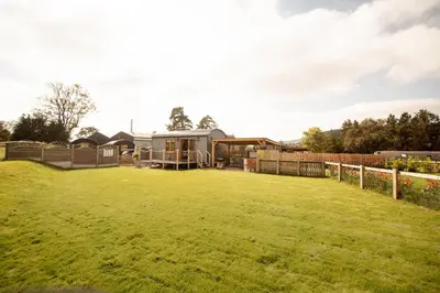 a grassy yard with a house in the background at Lily in Rhayader