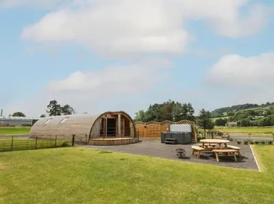 a small wooden building with a picnic table and a grill at Primrose in Rhayader