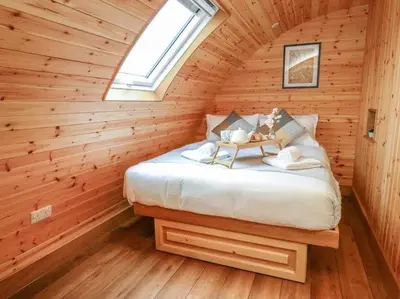 a bedroom with a bed in a wooden cabin at Primrose in Rhayader