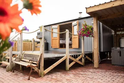 a patio with a bench and a trailer with flowers at Rose in Rhayader