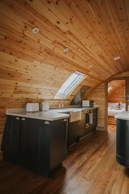 a kitchen in a log cabin with a large window at Snowdrop in Rhayader