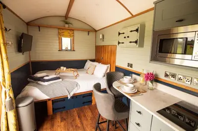 a small bedroom with a bed and a table and chairs at Tulip in Rhayader