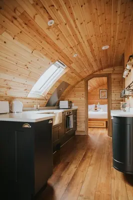 a kitchen with a wooden ceiling with a sink and a stove at Daisy in Rhayader