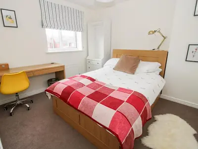 a bedroom with a bed and a desk and a desk at 30 Poplar Close in Shrewsbury