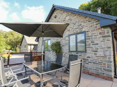 a table and chairs with an umbrella on a patio at Pen Y Banc in Builth Wells
