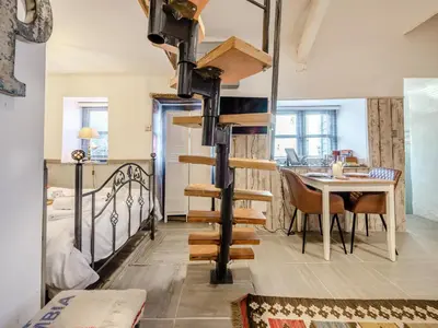 a room with a bed and a table and a spiral staircase at Tegfan in Henfynyw Upper