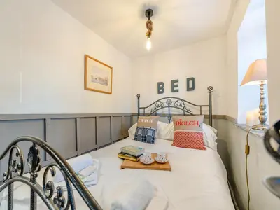 a bedroom with a bed with a table on it at Tegfan in Henfynyw Upper