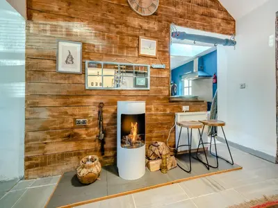 a living room with a wooden wall with a fireplace at Tegfan in Henfynyw Upper