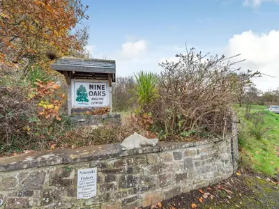a stone wall with a sign that reads king owls condos at Craigfryn in Llanerch-Aeron