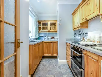 a kitchen with wooden cabinets and a stove top oven at Craigfryn in Llanerch-Aeron