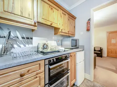 a kitchen with wooden cabinets and a stove top oven at Craigfryn in Llanerch-Aeron