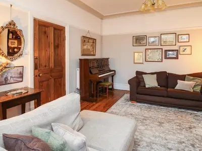 a living room with a couch and a piano at Tirallen in Llanwrda