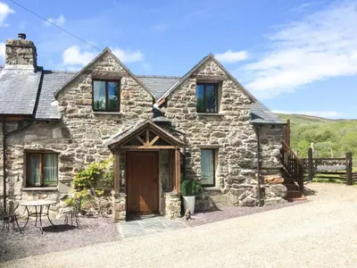 an old stone house with a wooden door at Hafan Prysor in Trawsfynydd