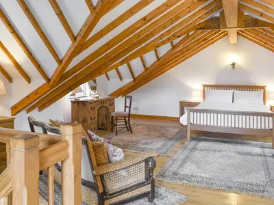 a bedroom in a loft with a bed and a desk at Hafan Prysor in Trawsfynydd