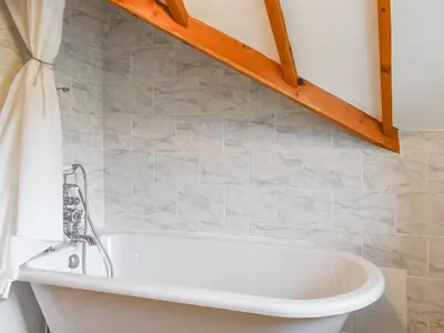 a bath tub in a bathroom with a shower at Hafan Prysor in Trawsfynydd