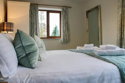 a bedroom with a large white bed with a window at Bedw Barn in Newtown
