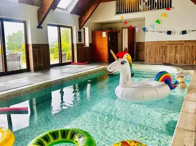 a swimming pool with a unicorn float in a house at Bedw Barn in Newtown