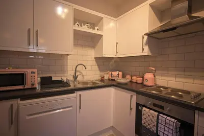 a kitchen with white cabinets and a sink and a microwave at Ground floor well appointed cosy flat in Ludlow in Ludlow