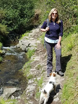 a woman and a dog standing next to a stream at Ground floor well appointed cosy flat in Ludlow in Ludlow