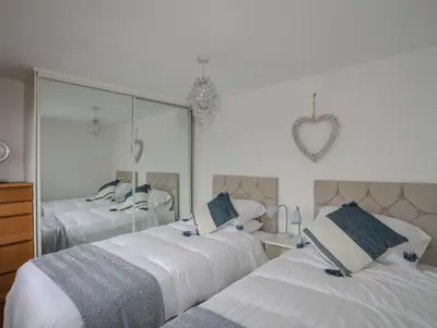 a bedroom with two beds and a mirror at Bramble Bank in Harlech