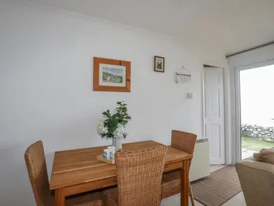 a dining room with a wooden table and chairs at Bramble Bank in Harlech