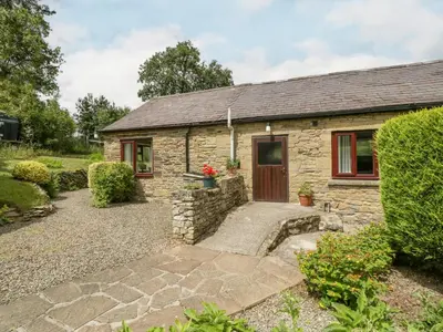 a stone cottage with a door and a courtyard at Fieldfare in Leominster