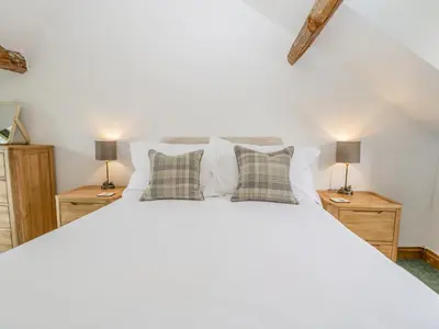 a bedroom with a large white bed with two lamps at Fieldfare in Leominster