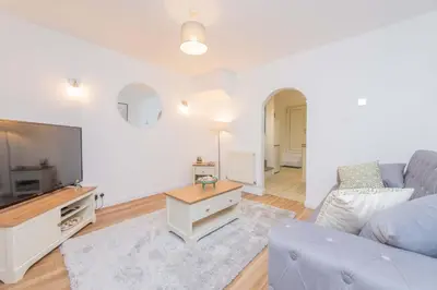 a living room with a blue couch and a tv at Hereford Road Shrewsbury Cottage in Shrewsbury