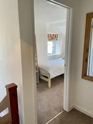 a room with a bedroom with a bed and a mirror at Taylor Way - Superb Apartment with Living Room and Private Gated Parking in Aberystwyth