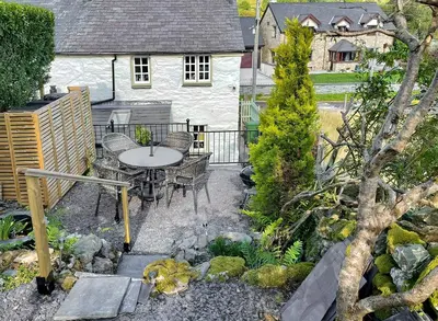a patio with a table and chairs in front of a house at Summerhill Tanyrhos in Blaenau-Ffestiniog