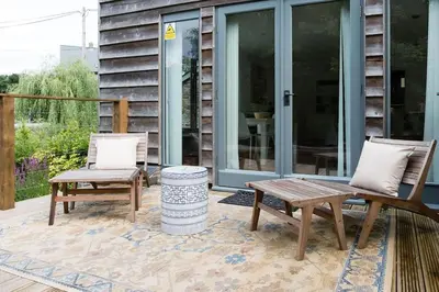 two chairs and a bench on a patio at Luxury Cottage near Hay-on-Wye in Llanigon