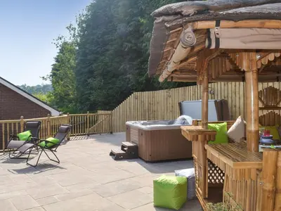 a patio with a hot tub and a gazebo at Gwynfan Bungalow in Llandrindod Wells